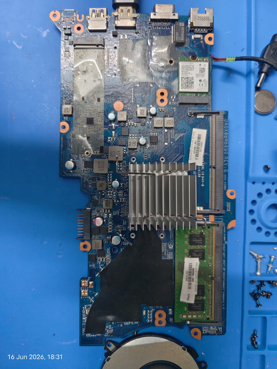 Laptop motherboard on a blue repair mat